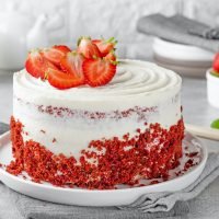 Red velvet cake with strawberries. Cake from red sponge cakes and cream cheese frosting,